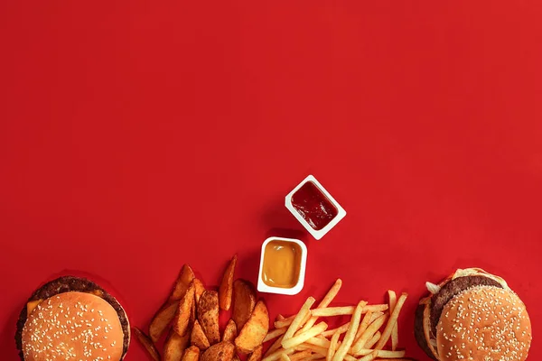Fast food yemek üstten görünüm. Et burger, patates cipsi ve nuggets kırmızı zemin üzerine. Paket servisi olan restoran kompozisyon. Üstten Görünüm — Stok fotoğraf