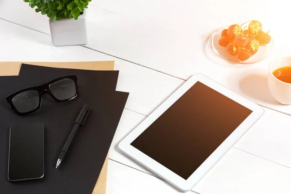 Сучасне робоче місце з цифровим планшетом і мобільним телефоном, чашкою кави, ручкою і порожнім аркушем паперу . — стокове фото