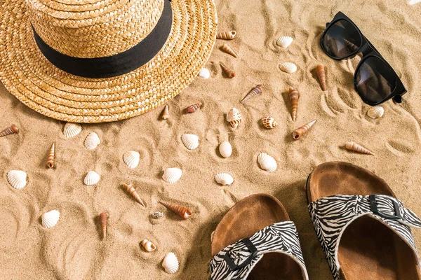 Beachwear, flip flop, şapka, güneş gözlüğü ve kabukları üzerinde kum plaj yaz.