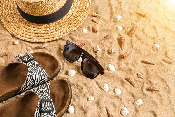 Lato, stroje kąpielowe, klapki, kapelusz, Okulary przeciwsłoneczne i muszle na plaży. — Zdjęcie stockowe