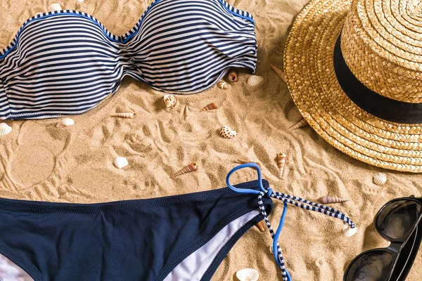 Bikini d'été et accessoires élégant ensemble de plage, Tenue d'été de bikini de plage et sable marin comme arrière-plan, Vue sur le dessus, Concept — Photo