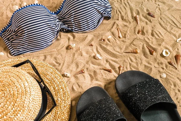 Bikini latem i akcesoria plaży stylowy zestaw, strój lata bikini plaża i morze piasek jako tło, widok z góry, koncepcja — Zdjęcie stockowe