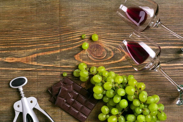 Glasses of wine and ripe grapes isolated on a wooden table — Stock Photo, Image