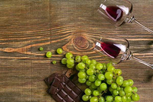 Copos de vinho e uvas maduras isolados numa mesa de madeira — Fotografia de Stock