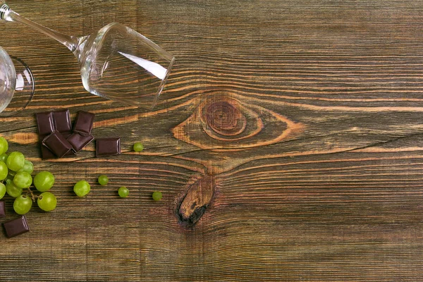 Copos de vinho e uvas maduras isolados numa mesa de madeira — Fotografia de Stock