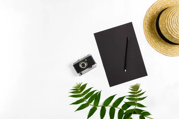 Straw hat with green leaves and old camera on white background, Summer background. Top view — Stock Photo, Image