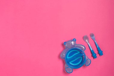 Bebek mavi tabak kaşık ve pink izole çatal ile. Üstten Görünüm
