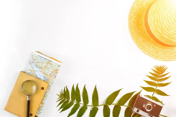 Hasır şapka ile yeşil yaprakları ve beyaz arka plan, yaz arka plan üzerinde eski fotoğraf makinesi. Üstten Görünüm. Güneş parlaması