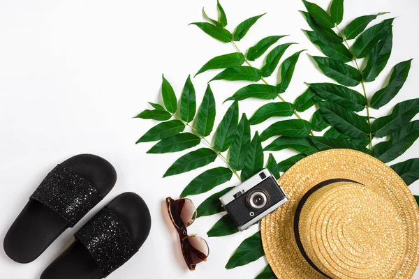 Stro hoed met groene bladeren en oude camera op witte achtergrond, zomer achtergrond. Bovenaanzicht — Stockfoto