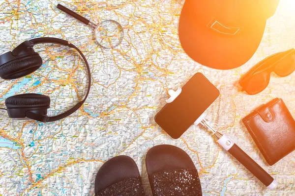 Akcesoria do podróży. Paszport, cap, inteligentny telefon i mapę podróży. Widok z góry. Rozbłysk słoneczny — Zdjęcie stockowe