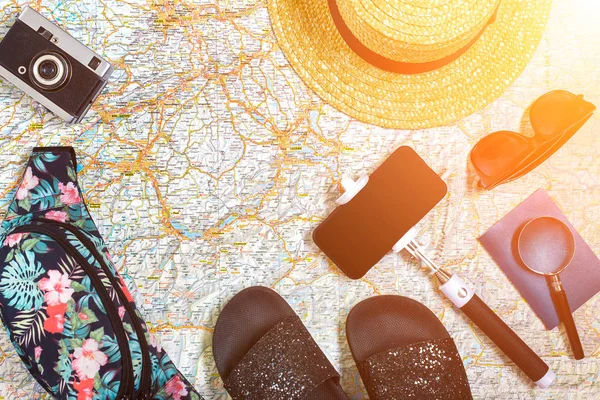 Doplňky pro cestování. Pas, klobouk, chytrý telefon a cestovní mapu. Pohled shora. Sluneční erupce — Stock fotografie