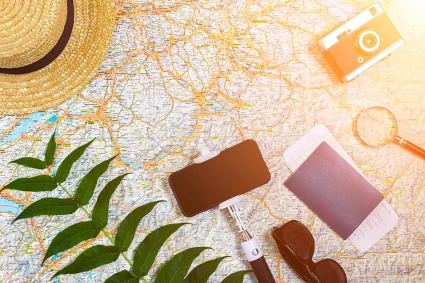 Аксессуары для путешествий. Паспорт, шляпа, смартфон и карта путешествий. Вид сверху. Солнечная вспышка — стоковое фото