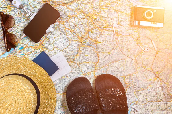 Аксессуары для путешествий. Паспорт, шляпа, смартфон и карта путешествий. Вид сверху. Солнечная вспышка — стоковое фото