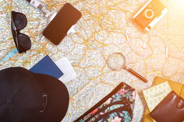 Zubehör für Reisen. Reisepass, Fotokamera, Smartphone und Reisekarte. Ansicht von oben. Sonneneruption — Stockfoto