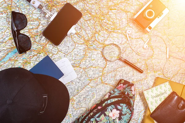 Zubehör für Reisen. Reisepass, Fotokamera, Smartphone und Reisekarte. Ansicht von oben. Sonneneruption — Stockfoto