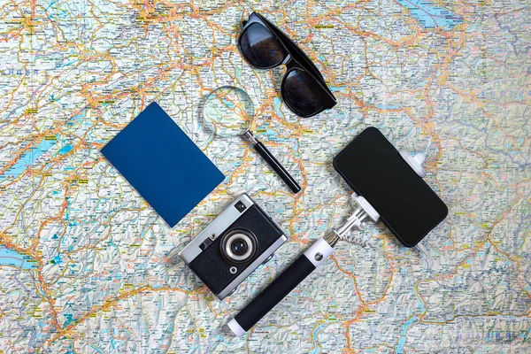 Conjunto de accesorios de viaje sobre fondo blanco: smart, pasaporte, mapa, cámara y gafas de sol. Punto de vista superior . — Foto de Stock