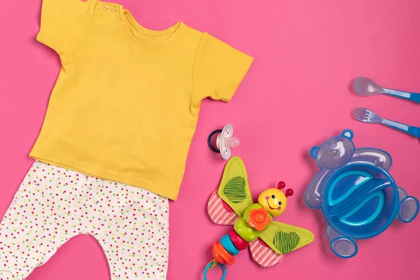 Roupas de bebê e acessórios em fundo rosa. Vista superior — Fotografia de Stock