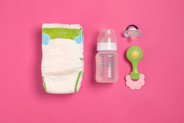 Baby care accessories and diapers on pink background. Top view — Stock Photo, Image