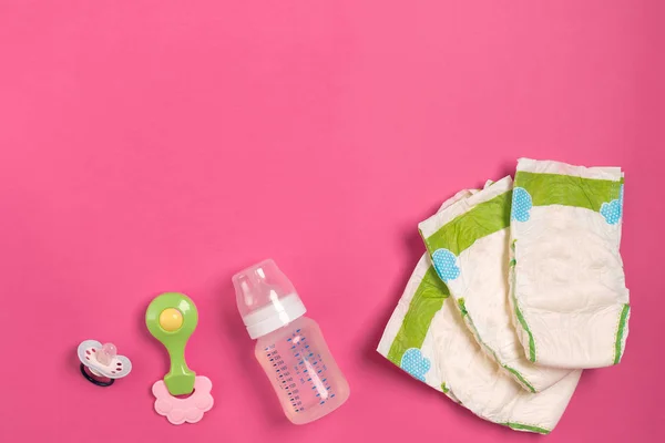 Baby care accessories and diapers on pink background. Top view — Stock Photo, Image