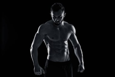 Poz yapan kaslı vücut geliştirmeci adam