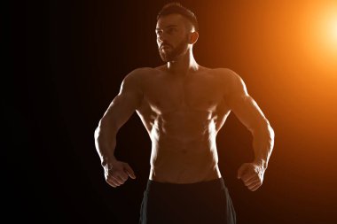 Poz yapan kaslı vücut geliştirmeci adam