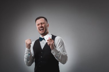 onun elinde iki as olan yakışıklı poker oyuncusu