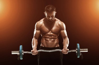 Kaslı adam koyu arka plan üzerinde ağırlık kaldırma