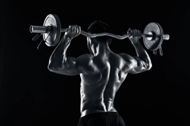 vücut geliştirmeci siyah arka plan üzerine bir halter kaldırma