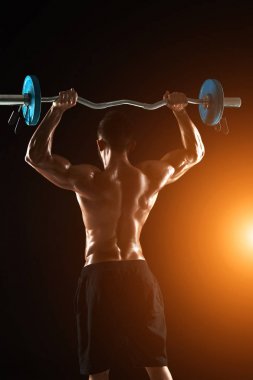 vücut geliştirmeci siyah arka plan üzerine bir halter kaldırma