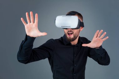 Vr kulaklık kullanarak ve gri arka plan üzerinde sanal gerçeklik karşılaşan duygusal delikanlı