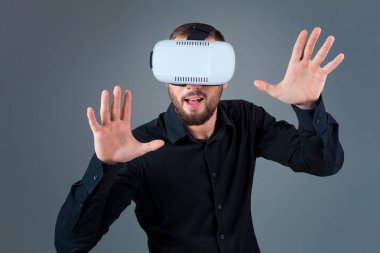 Vr kulaklık kullanarak ve gri arka plan üzerinde sanal gerçeklik karşılaşan duygusal delikanlı