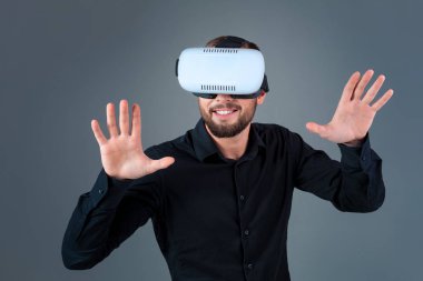 Vr kulaklık kullanarak ve gri arka plan üzerinde sanal gerçeklik karşılaşan duygusal delikanlı