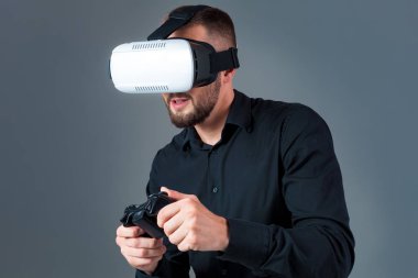 Vr kulaklık kullanarak ve gri arka plan üzerinde sanal gerçeklik karşılaşan duygusal delikanlı