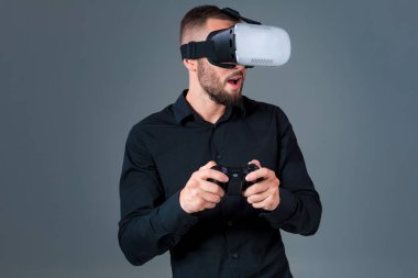 Vr kulaklık kullanarak ve gri arka plan üzerinde sanal gerçeklik karşılaşan duygusal delikanlı