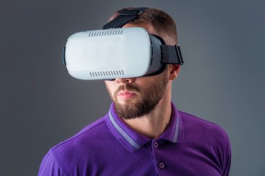 Vr kulaklık kullanarak ve gri arka plan üzerinde sanal gerçeklik karşılaşan duygusal delikanlı