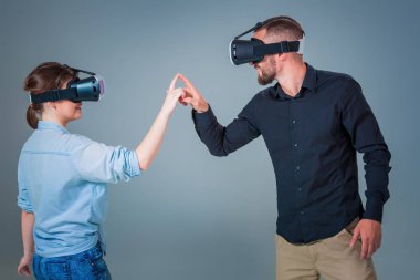 Genç çift gri arka plan üzerinde VR kulaklık kullanarak