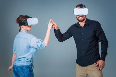 Genç çift gri arka plan üzerinde VR kulaklık kullanarak