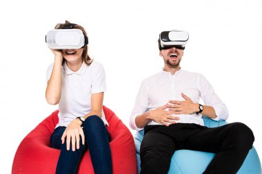Sanal gerçeklik beyaz arka plan üzerinde izole beanbags üzerinde oturmuş yaşandığı heyecanlı genç Çift