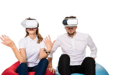 Sanal gerçeklik beyaz arka plan üzerinde izole beanbags üzerinde oturmuş yaşandığı heyecanlı genç Çift