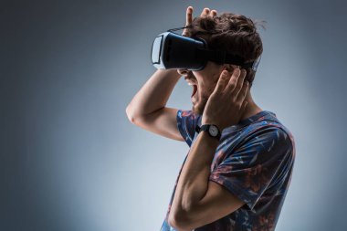 Genç bir adam bir Vr kulaklık kullanarak yan görünüm. Duygular