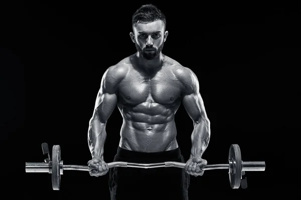 Muscular man lifting weights over dark background — Stock Photo, Image