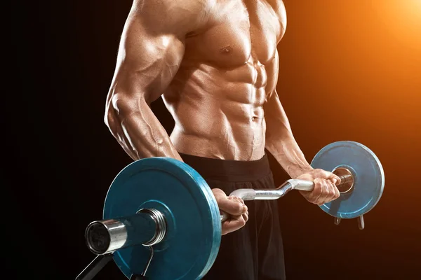Muscular hombre levantamiento de pesas sobre fondo oscuro —  Fotos de Stock