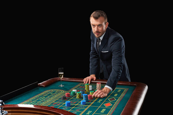 man in suit playing roulette. addiction to gambling.