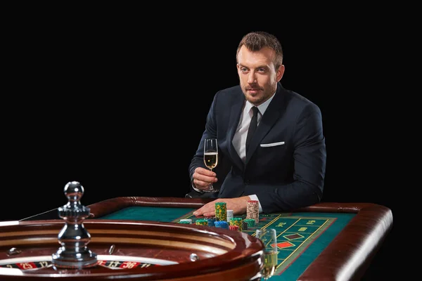man in suit playing roulette. addiction to gambling.