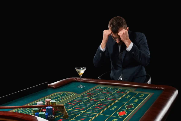 Ο άνθρωπος στο κοστούμι παίζοντας ρουλέτα. εθισμού στα τυχερά παιχνίδια. — Φωτογραφία Αρχείου