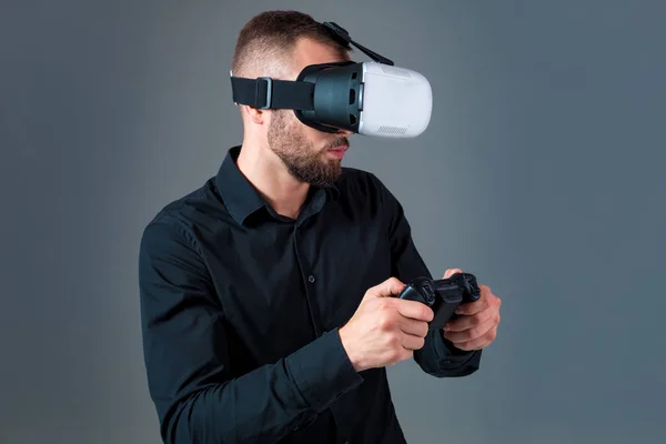 Συναισθηματική νεαρός χρησιμοποιώντας μια συσκευή VR και βιώνει εικονικής πραγματικότητας σε γκρίζο φόντο — Φωτογραφία Αρχείου