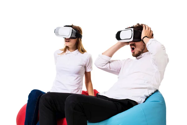 Ενθουσιασμένος ζευγάρι βιώνει την εικονική πραγματικότητα που κάθονται στο beanbags απομονώνονται σε λευκό φόντο — Φωτογραφία Αρχείου