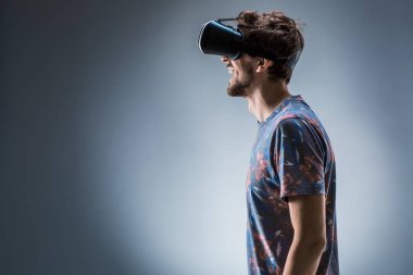 Genç bir adam bir Vr kulaklık kullanarak yan görünüm. Duygular