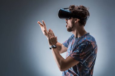 Genç bir adam bir Vr kulaklık kullanarak yan görünüm. Duygular