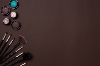 Çeşitli kozmetik ve fırçalar kahverengi zemin üzerine